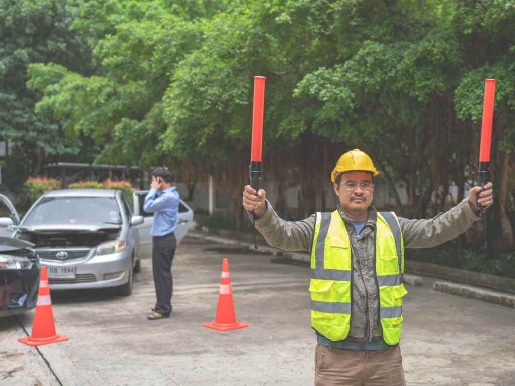 Agente de trânsito sinalizando um acidente de carros.